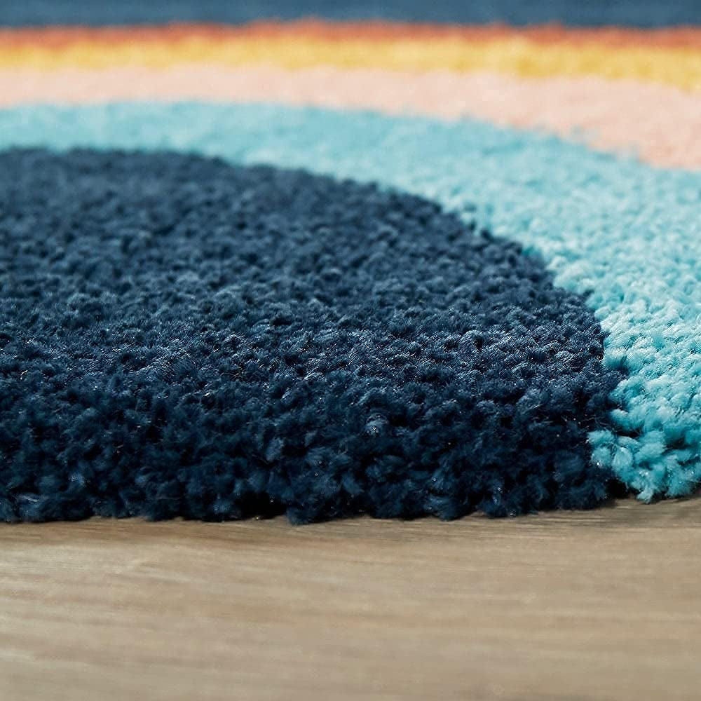 Close-up of a textured blue and multicolored rug on a wooden floor.