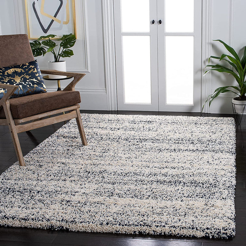 Living room with a textured area rug, chair, and plants.