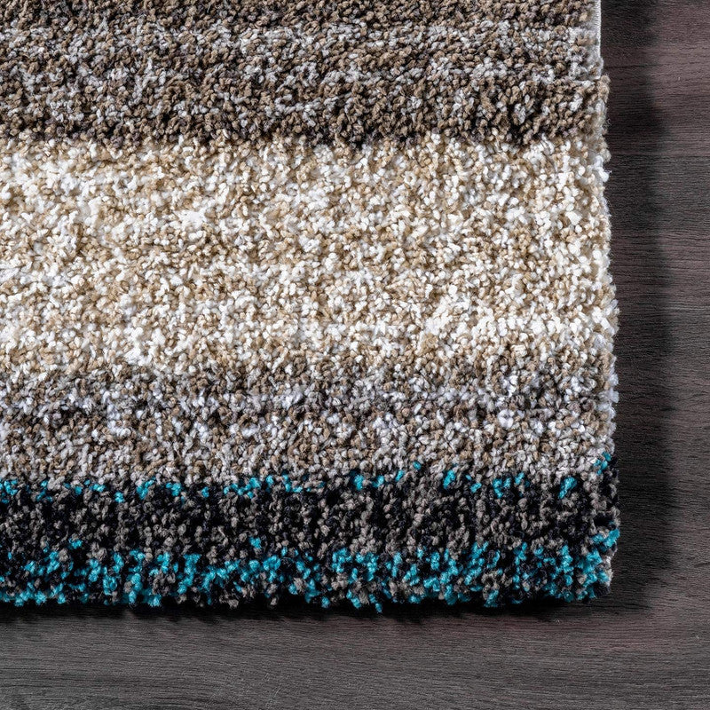 Close-up of textured rug with color gradient on wooden floor