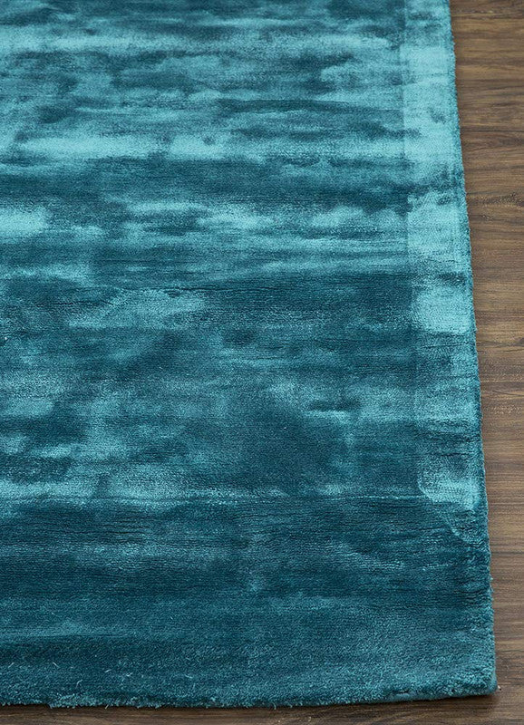 Teal rug on a wooden floor