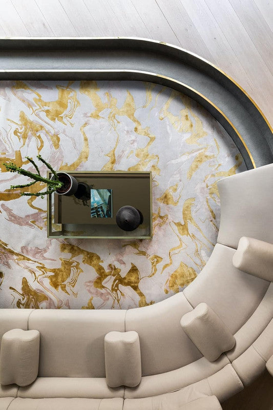 Round marble table with gold accents in a modern living room setting.