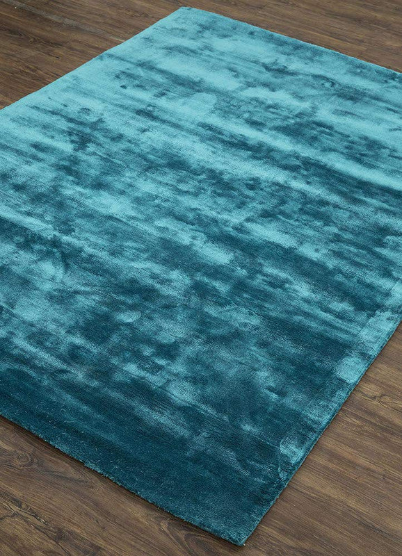 Teal rug on a wooden floor