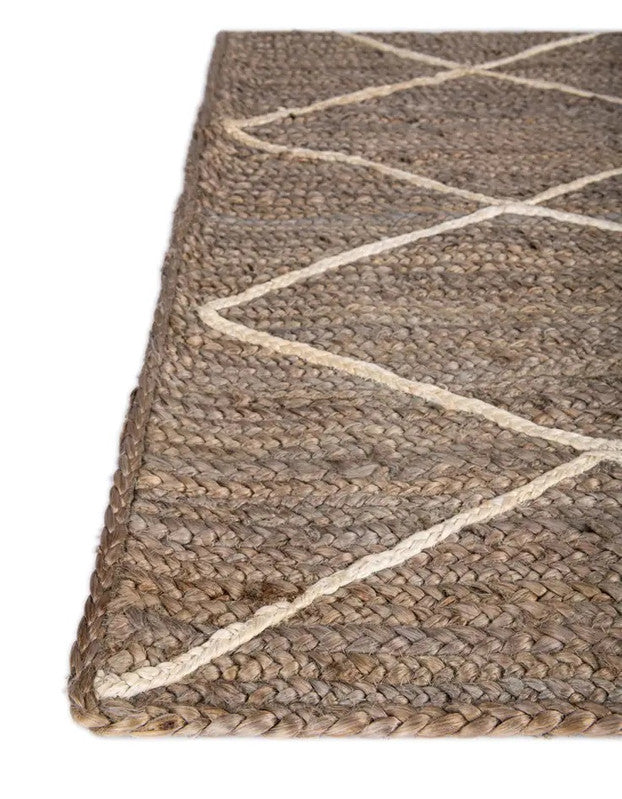 Brown woven rug with white geometric pattern on a plain background