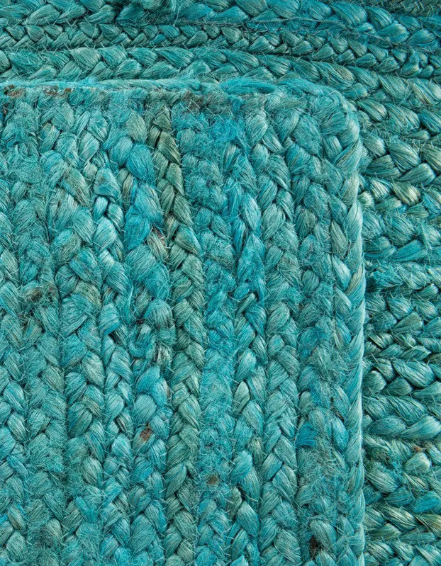 Close-up of a textured teal rug with braided pattern