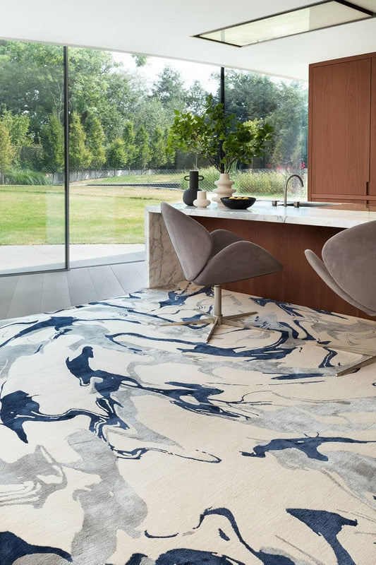 Modern kitchen with a large window view of greenery, featuring a patterned rug.