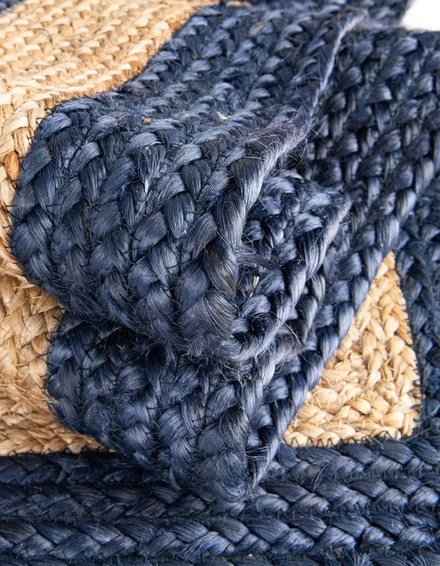 Close-up of a blue braided rug with a beige border