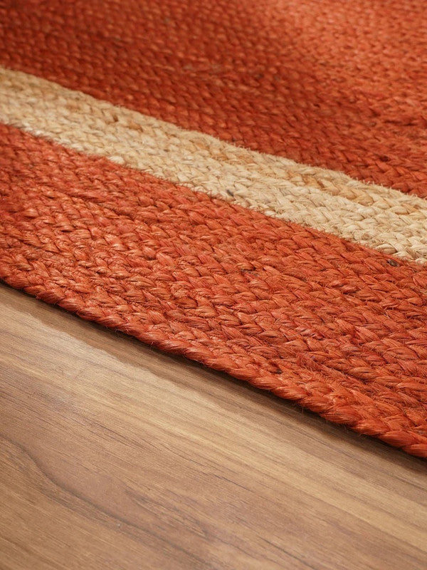 Close-up of a textured orange rug on a wooden floor