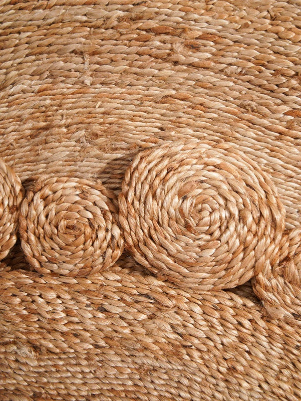 Close-up of a woven jute rug with circular patterns