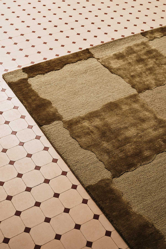 Brown textured rug on a patterned floor