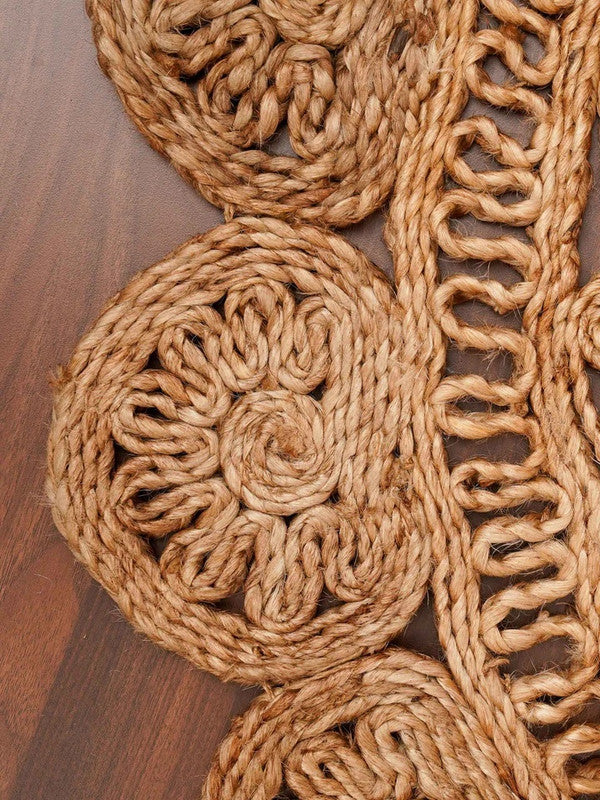 Close-up of a woven jute mat with intricate patterns on a wooden surface