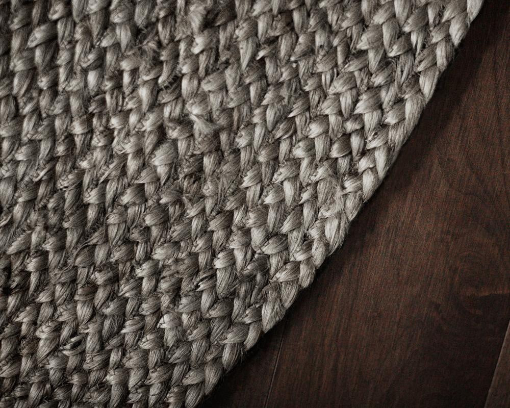 Close-up of a textured woven mat on a wooden floor