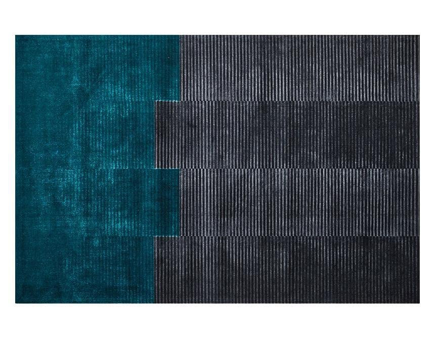 Teal and black patterned rug on a white background